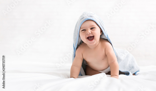 Cute little baby boy in hooded towel after bath