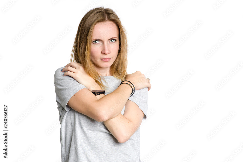 Portrait of a sad woman who has clasped herself in fear, isolated on a white background. Portrait of a sad woman who has clasped herself in fear, isolated on a white background.