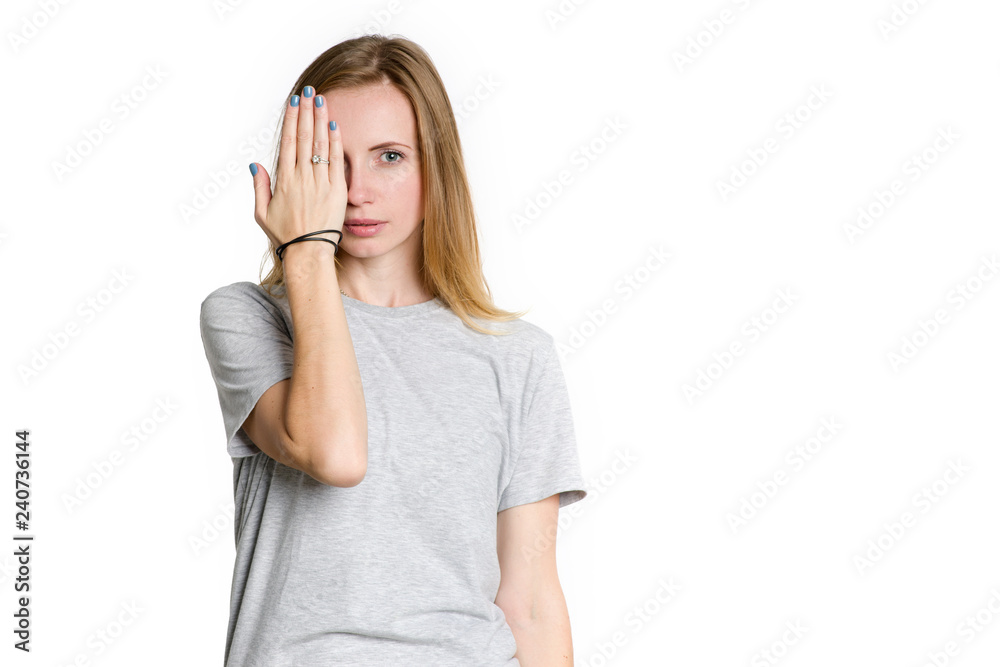 Portrait of a young woman who covered her hand with one eye isolated on a white background. Portrait of a young woman who covered her hand with one eye isolated on a white background.