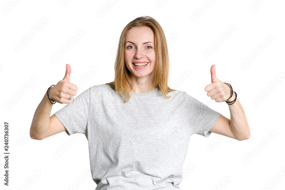Portrait of a young woman showing thumbs up on a white background. Portrait of a young woman showing thumbs up on a white background.