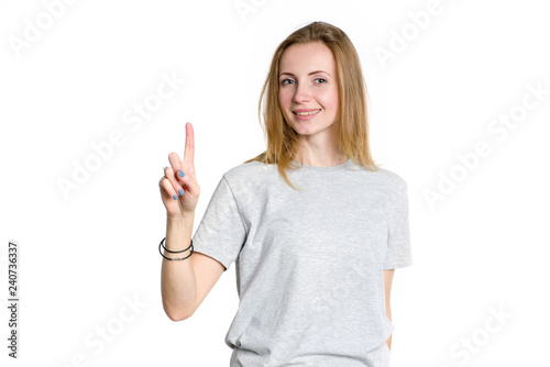 Portrait of a young woman who shows one finger. Gesture - number 1.