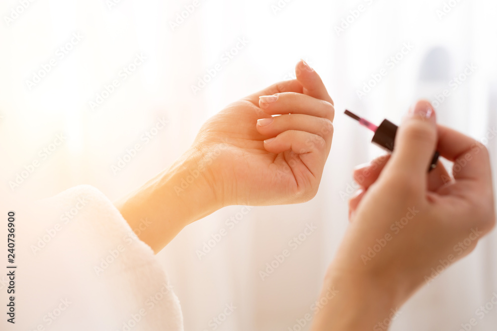 Close up of a shapely woman painted her nails in the morning, while sitting on the bed being dressed in a dressing-gown. Close up of a shapely woman painted her nails in the morning, while sitting on the bed being dressed in a dressing-gown.