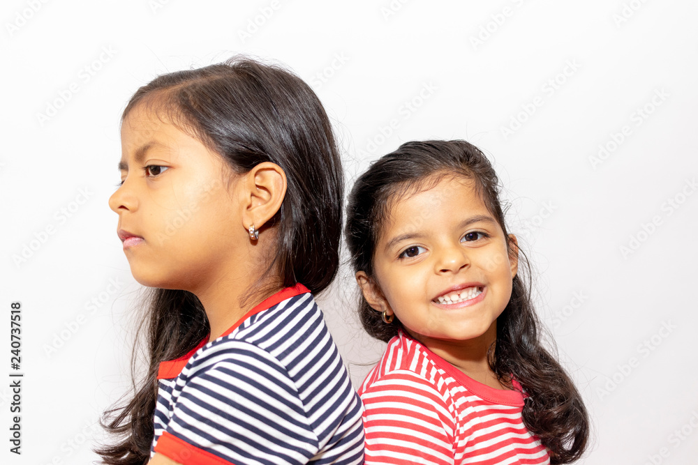 Cute sisters with striped dresses laughing Cute sisters with striped dresses laughing