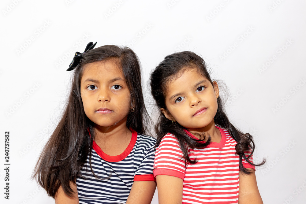 Cute sisters with striped dresses laughing