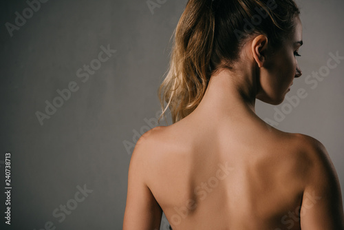 back view of woman with ponytail on grey background