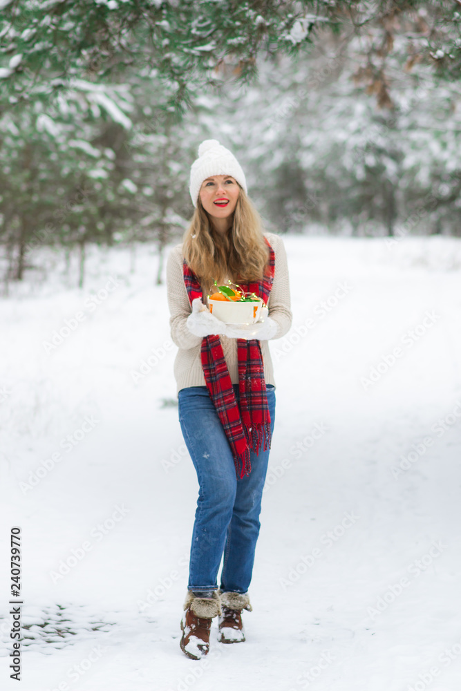 Young happy woman in winter clothes walks in the snowy forest Young happy woman in winter clothes walks in the snowy forest