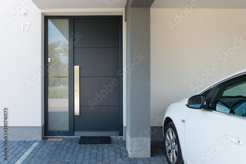 Modern house entrance with parking car next to it photo