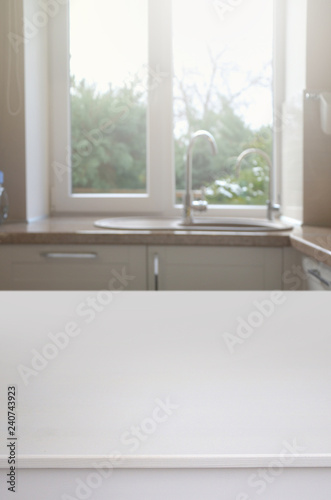 White table against a blurred window in the interior of the kitchen.