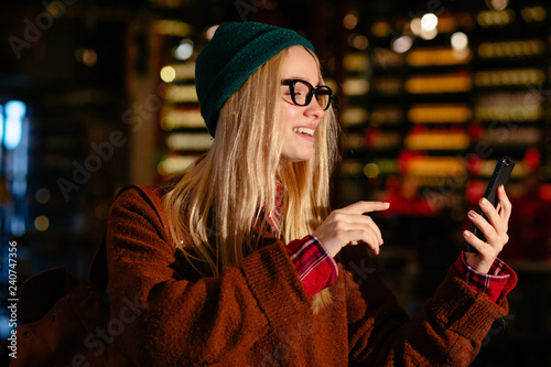 Casual business woman, hipster, freelancer using mobile smart phone checking internet application, close up portrait, always in touch with social media, keep connection, internet of things concept photo