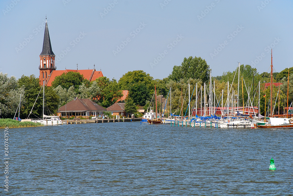 Fototapeta premium Harbor and church in Wustrow. Wustrow is a municipality at Baltic Sea coast in Mecklenburg-Vorpommern, Fischland, Germany