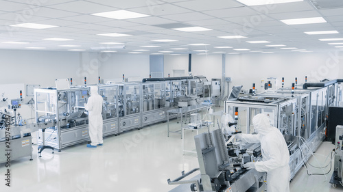 Sterile High Precision Manufacturing Laboratory where Scientists in Protective Coverall's Turn on Machninery, Use Computers and Microscopes, doing Pharmaceutics and Semiconductor Research.