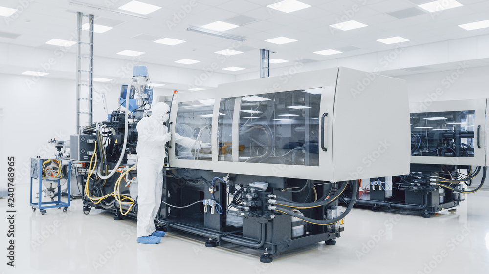 On a Factory Scientist in Sterile Protective Clothing Work on a Modern Industrial 3D Printing Machinery. Pharmaceutical, Biotechnological and Semiconductor Creating / Manufacturing Process. On a Factory Scientist in Sterile Protective Clothing Work on a Modern Industrial 3D Printing Machinery. Pharmaceutical, Biotechnological and Semiconductor Creating / Manufacturing Process.