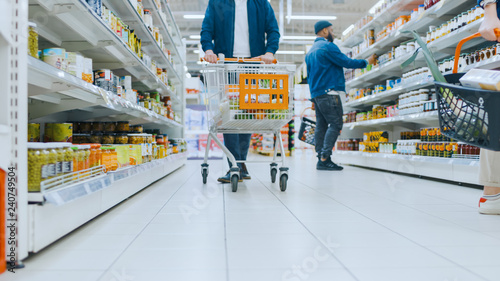 Low Angle Footage At the Supermarket: Canned Goods Section, Customers Browsing Through Shelves and Buying Products.