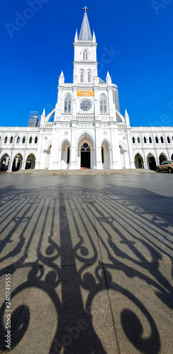 Vertical panoramic view of the Chijmes where is the historic Gothic style church with the shadow of the entrance gate in foreground.