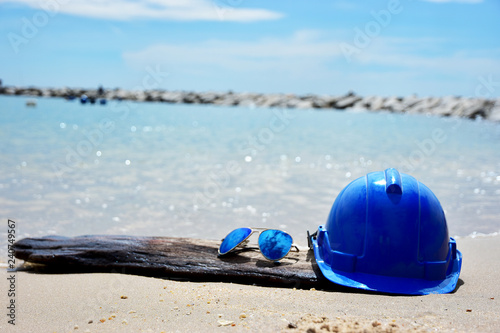 Safety Helmet and the sun glasses on the seascape background