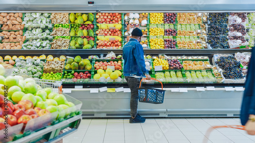 At the Supermarket: Happy Black Stylish Guy with Shopping Basket Shopping for Organic Fruits and Vegetables in the Fresh Produce Section of the Store.