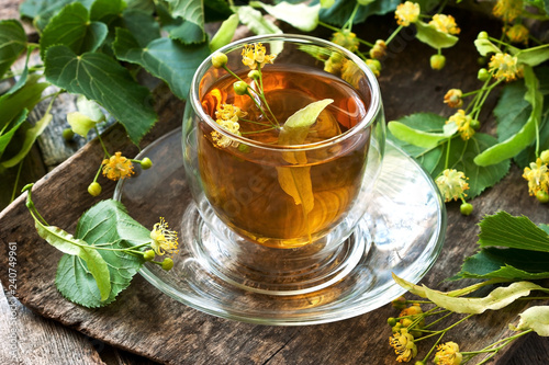 Linden flowers and cup of healthy tea, herbal medicine