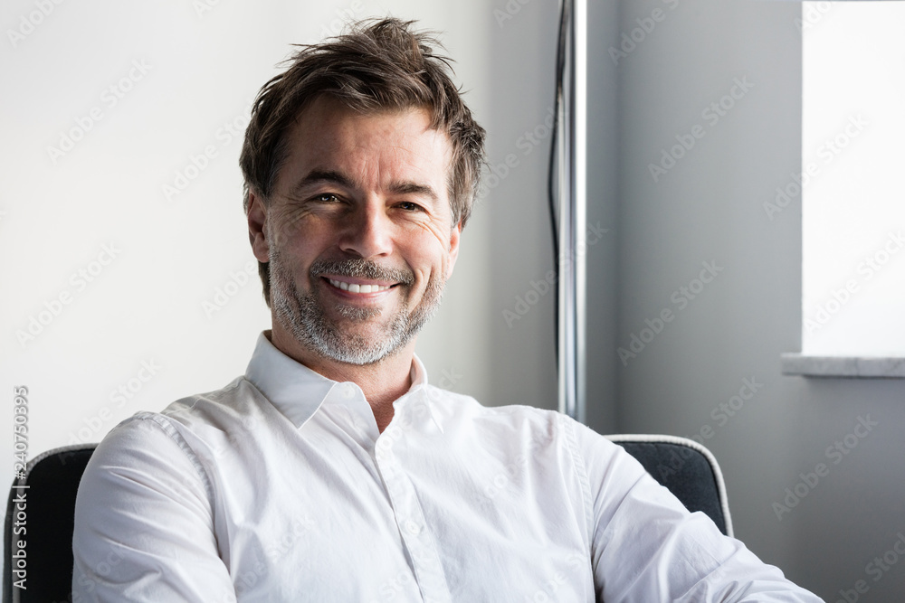Handsome smiling man relaxing in a sofa at the hotel Handsome smiling man relaxing in a sofa at the hotel