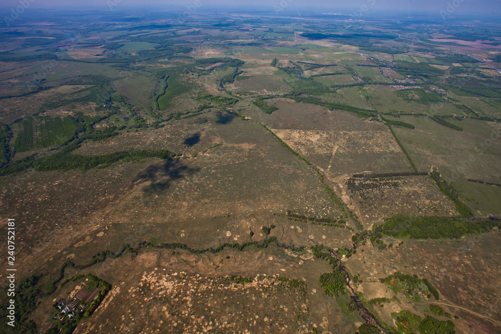 Flight over the plain with rivers, fields and forests.