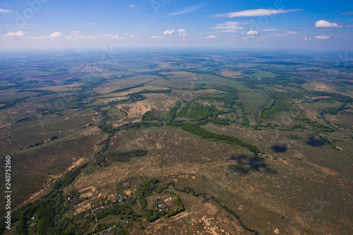 Flight over the plain with rivers, fields and forests.