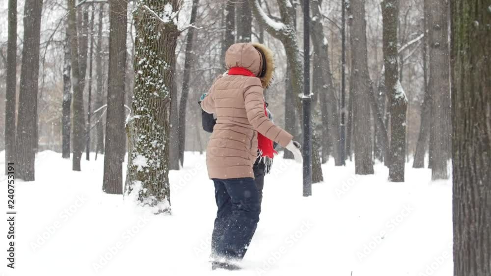 Two girls in winter park playing catch ups and snowballs together and having fun Two girls in winter park playing catch ups and snowballs together and having fun