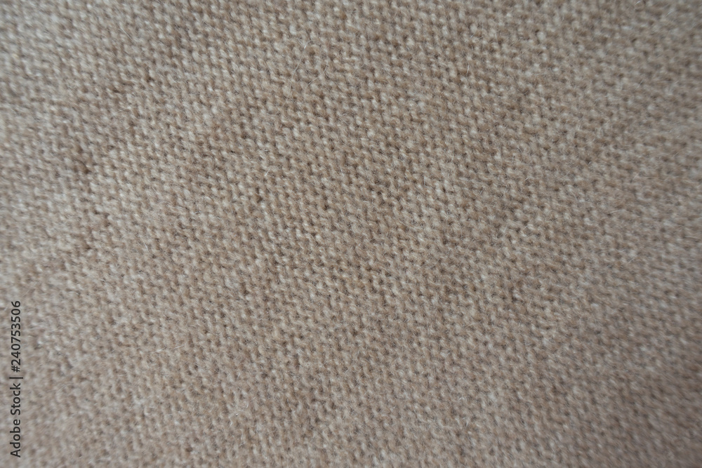 Diagonal view of beige knitted fabric made with reverse stockinette stitch