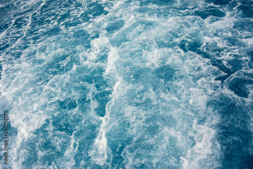 Background shot of blue aqua sea water with foam surface