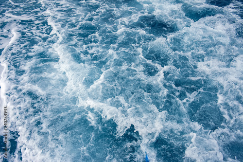 Background shot of blue aqua sea water with foam surface