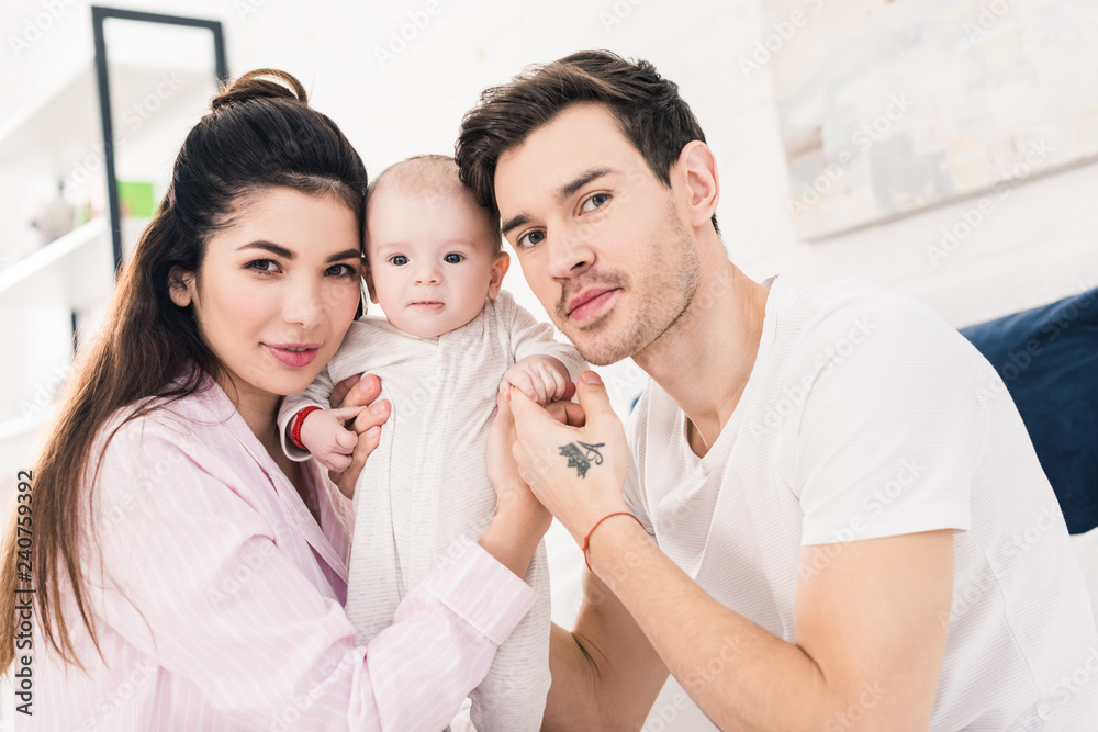 portrait of young parents with little son at home