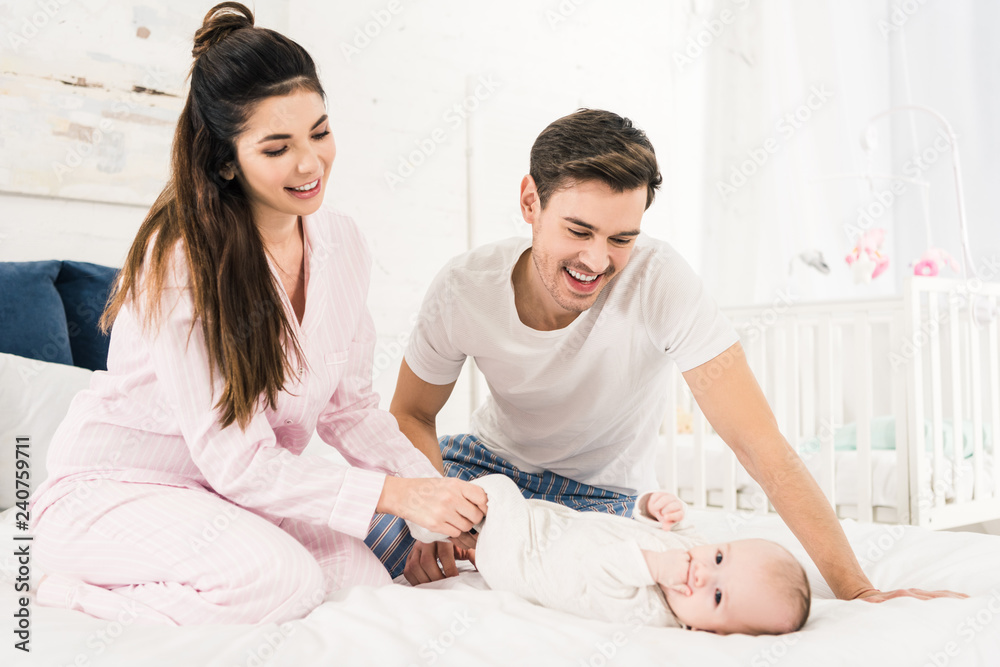 happy parents resting on bed together with cute baby at home happy parents resting on bed together with cute baby at home