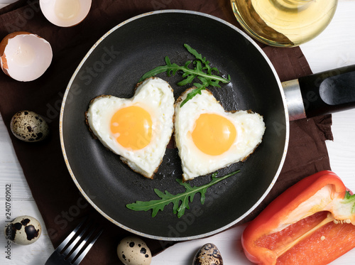fried eggs in the shape of a heart in a pan