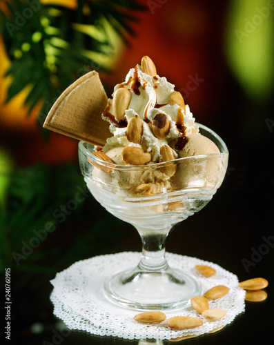 Canvas Print Una copa de helado con dos bolas una de vainilla y otra de turrón de almendra, nata montada y almendras naturales