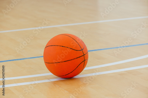 Basketball on a hardwood court floor as a sports and fitness symbol of a team leisure activity playing with a leather ball dribbling and passing in competition tournaments. © Augustas Cetkauskas