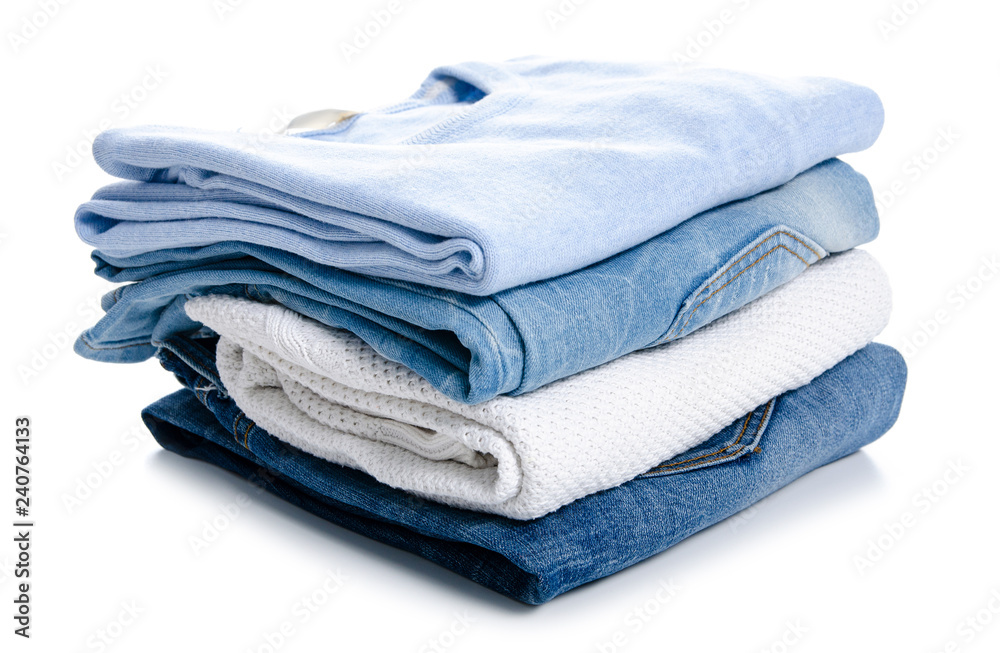 Stack of clothing jeans sweaters on a white background isolation Stack of clothing jeans sweaters on a white background isolation