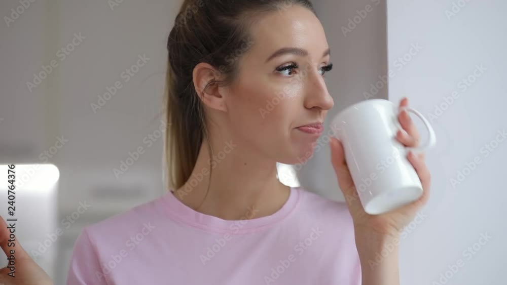 Young woman in pink t-thirt enjoy drinking tea with winter cookie at home Young woman in pink t-thirt enjoy drinking tea with winter cookie at home