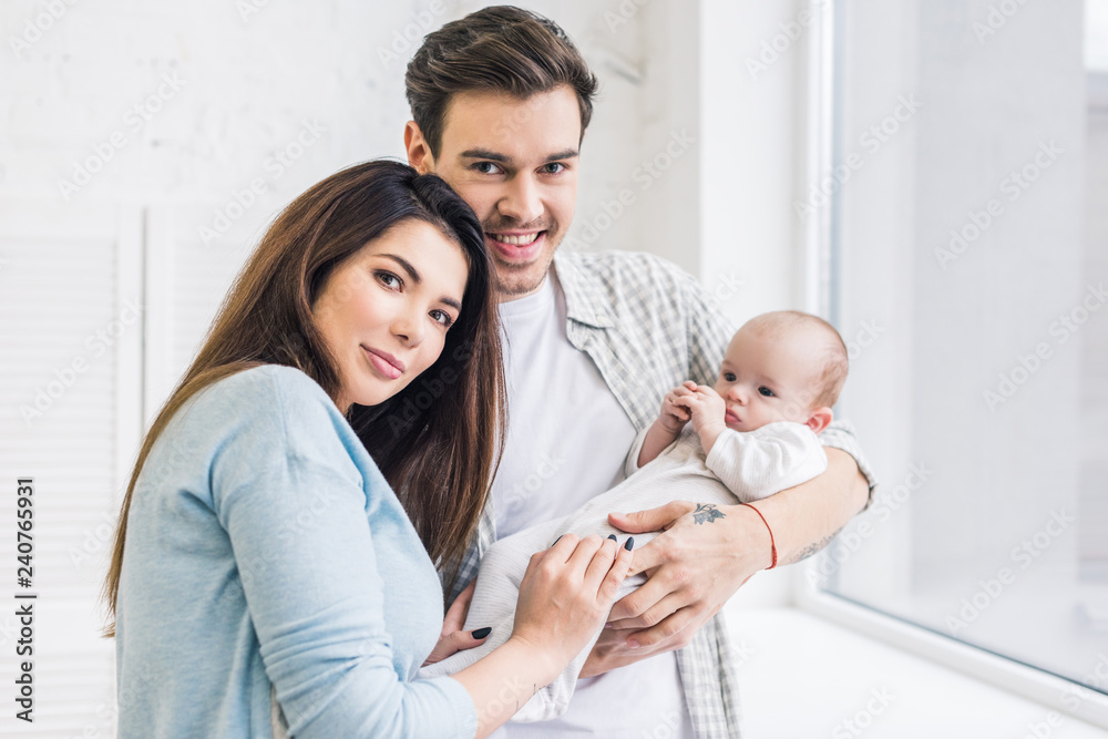 Obraz premium portrait of young parents with baby at home