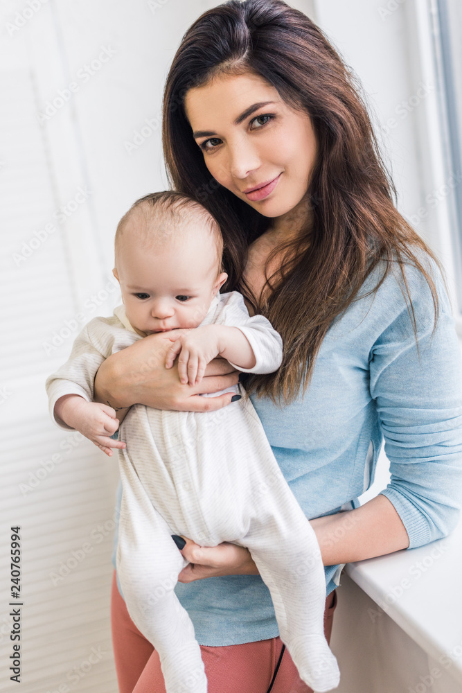portrait of beautiful young mother holding little son in hands at home portrait of beautiful young mother holding little son in hands at home