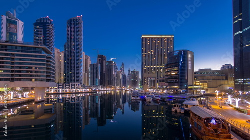 Fototapeta Naklejka Na Ścianę i Meble -  View of Dubai Marina Towers and canal in Dubai night to day timelapse