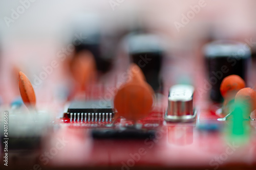 Close up (Macro) of Printed Circuit Board PCB embedded components (inductors, resistors, capacitors, diodes, microchips, transistor) with short depth of view