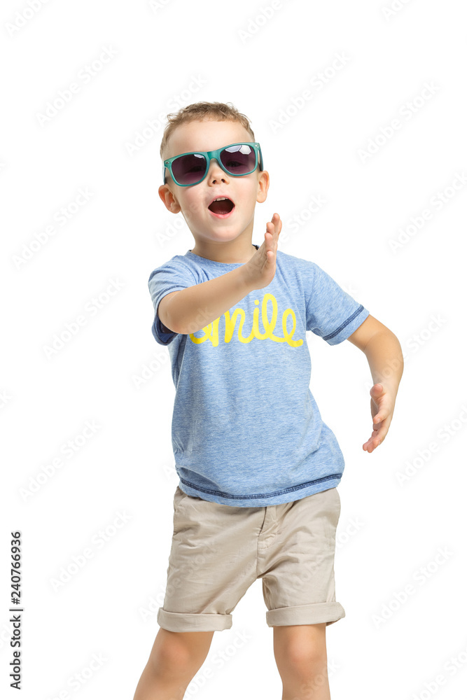 Full length portrait of cute little kid boy in stylish clothes looking at camera and smiling, standing against white studio wall. Kids fashion concept Full length portrait of cute little kid boy in stylish clothes looking at camera and smiling, standing against white studio wall. Kids fashion concept