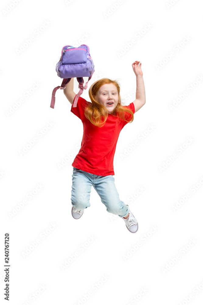 Full length portrait of cute little kid girl in stylish jeans clothes jumping against white studio wall. Kids fashion concept Full length portrait of cute little kid girl in stylish jeans clothes jumping against white studio wall. Kids fashion concept