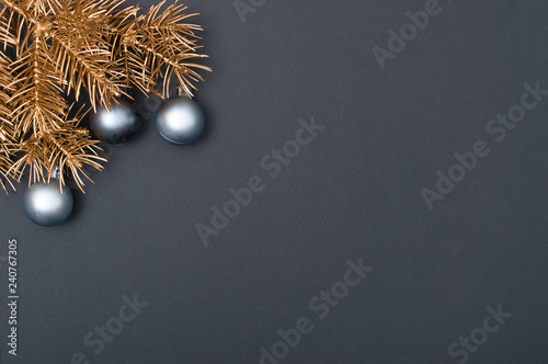 Creative decoration pattern with golden Christmas tree branches and silver baubles. Concept