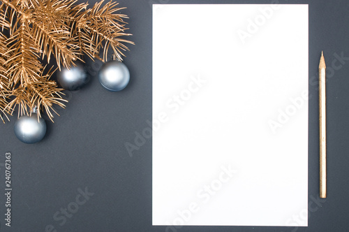 Creative decoration pattern with golden Christmas tree branches, baubles and pencil with copy space