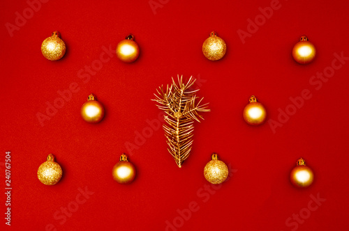 Multiple Christmas gold baubles creative decoration pattern with golden pine tree branch on the red background