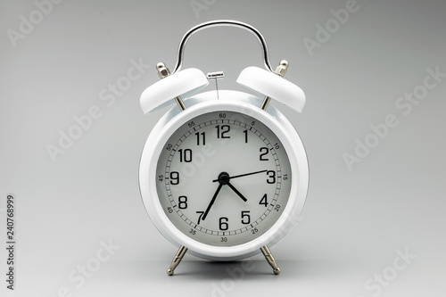 White vintage alarm clock on neutral background. Concept of time, time management, efficiency and scheduling of work