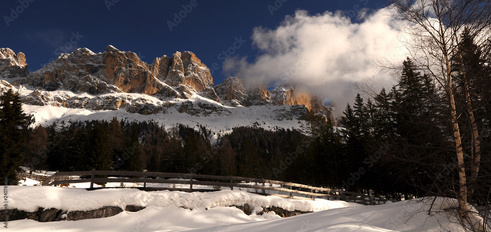 Beautiful Dolomites winter landscape at Passo of Costalunga with the Mountains Group of Catinaccio on the background, Trentino Alto-Adige, Northern Italy.