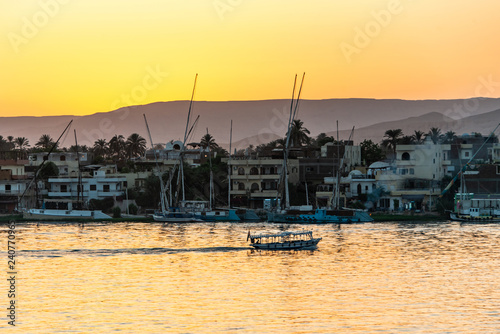 View of the Nile river with sailboats at golden colorful sunset in Luxor, Egypt © CL-Medien