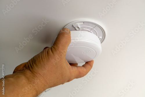 Fotografie Man installing smoke or carbon monoxide detector