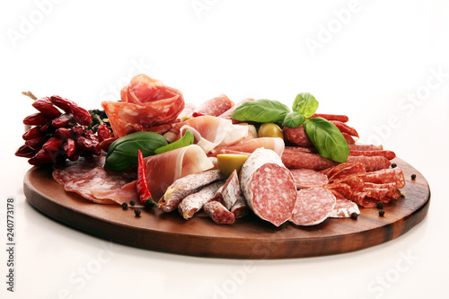 Fototapeta Naklejka Na Ścianę i Meble -  Food tray with delicious salami, pieces of sliced prosciutto crudo, sausage and basil. Meat platter with selection