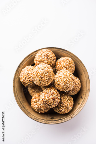 Tilgul Laddu or Til Gul balls for makar sankranti, it's a healthy food made using sesame, crushed peanuts and jaggery. served in a bowl. selective focus showing details.